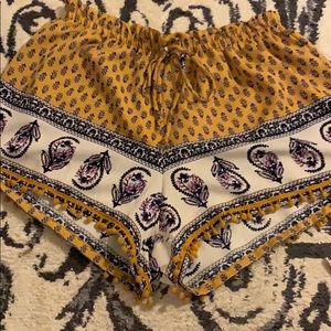 About a girl yellow, white, black flowy shorts.